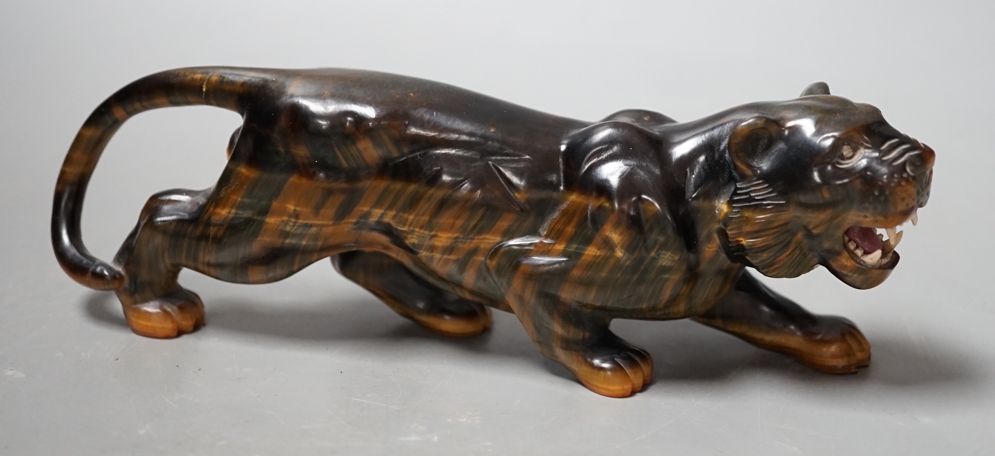 A carved tigers eye model of a tiger with paste set eyes. Makers mark ‘WG’ to paw underside. Numbered 974. 19cm long